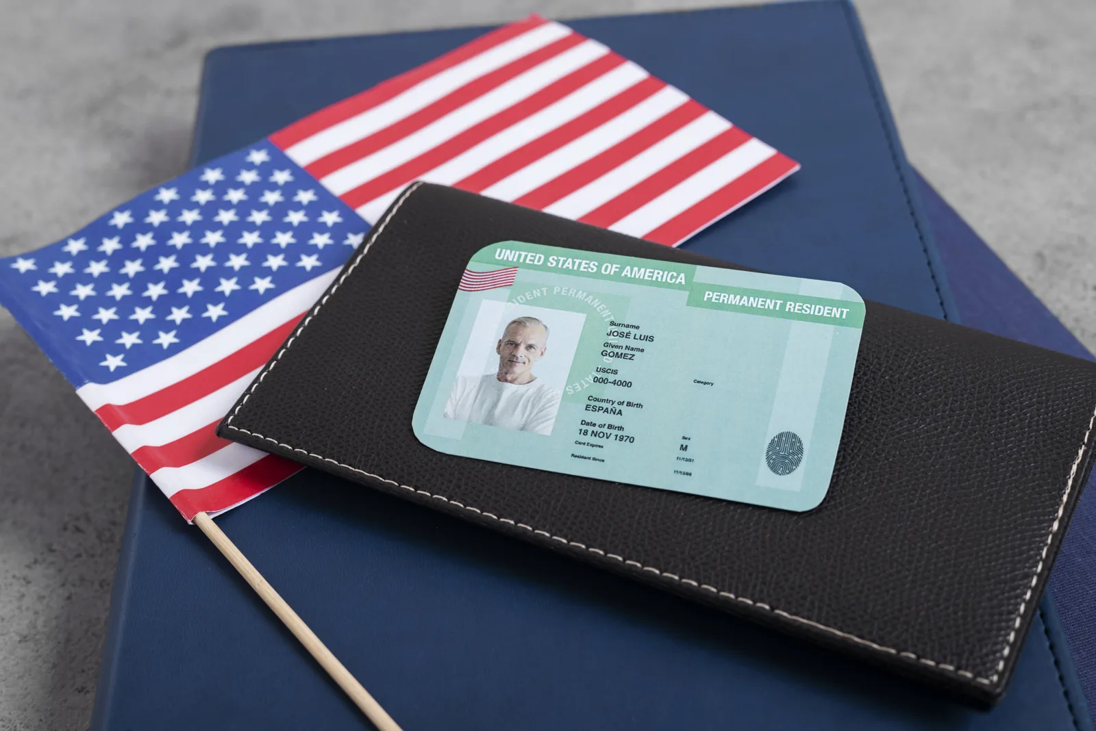 Tarjeta de residencia permanente junto a la bandera de Estados Unidos